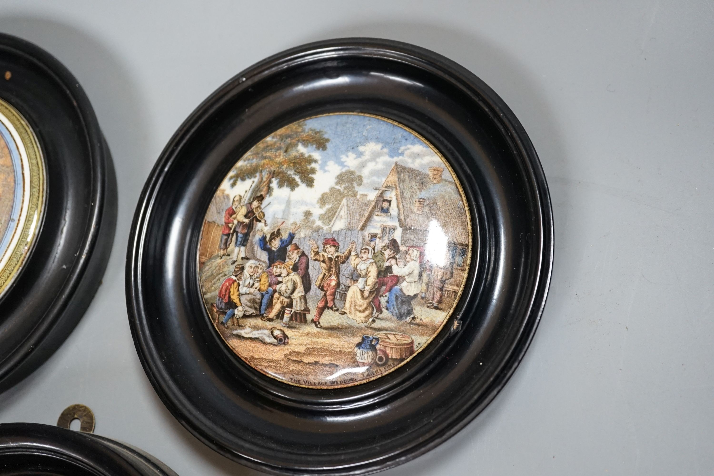 Seven Prattware pot lids, mounted in ebonised wood frames, an F & R Pratt plate and two pot lids with bases